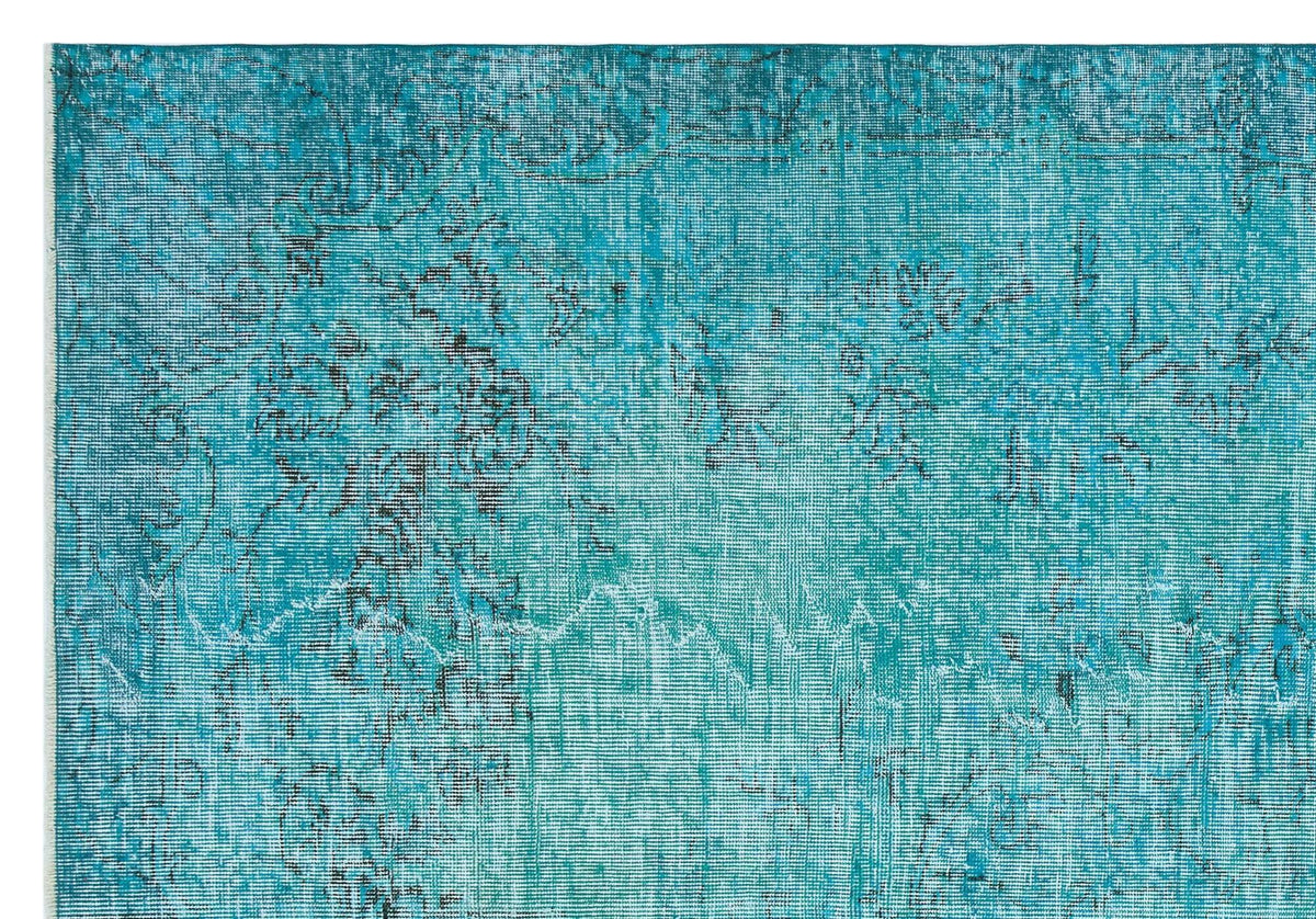 Teal distressed rug with a faded black traditional floral pattern on a white background.