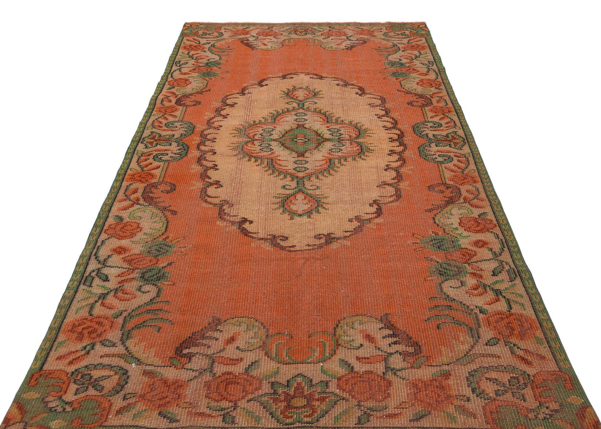 Orange and beige vintage-style rug with a central floral medallion and a decorative floral border.