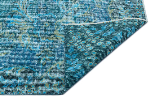Load image 1 in gallery view. Blue and teal distressed rug with a traditional floral medallion pattern, shown with a corner folded over.