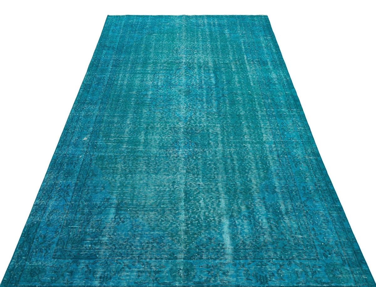 Teal distressed vintage-style rug with a faded traditional medallion pattern on a white background.