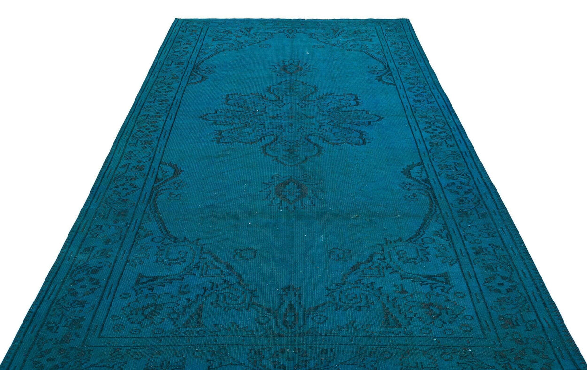 Teal rug with a dark blue traditional medallion pattern and ornate border on a white background.