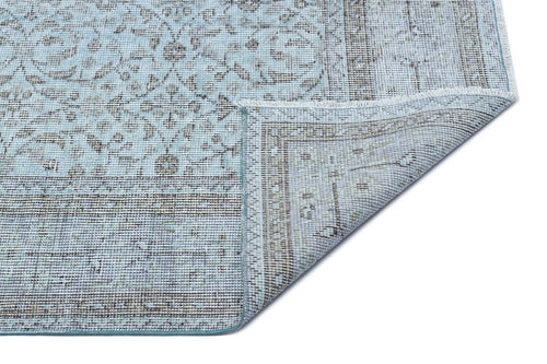 Load image 1 in gallery view. Light blue and grey traditional medallion rug with a folded corner showing the woven backing on a white background.