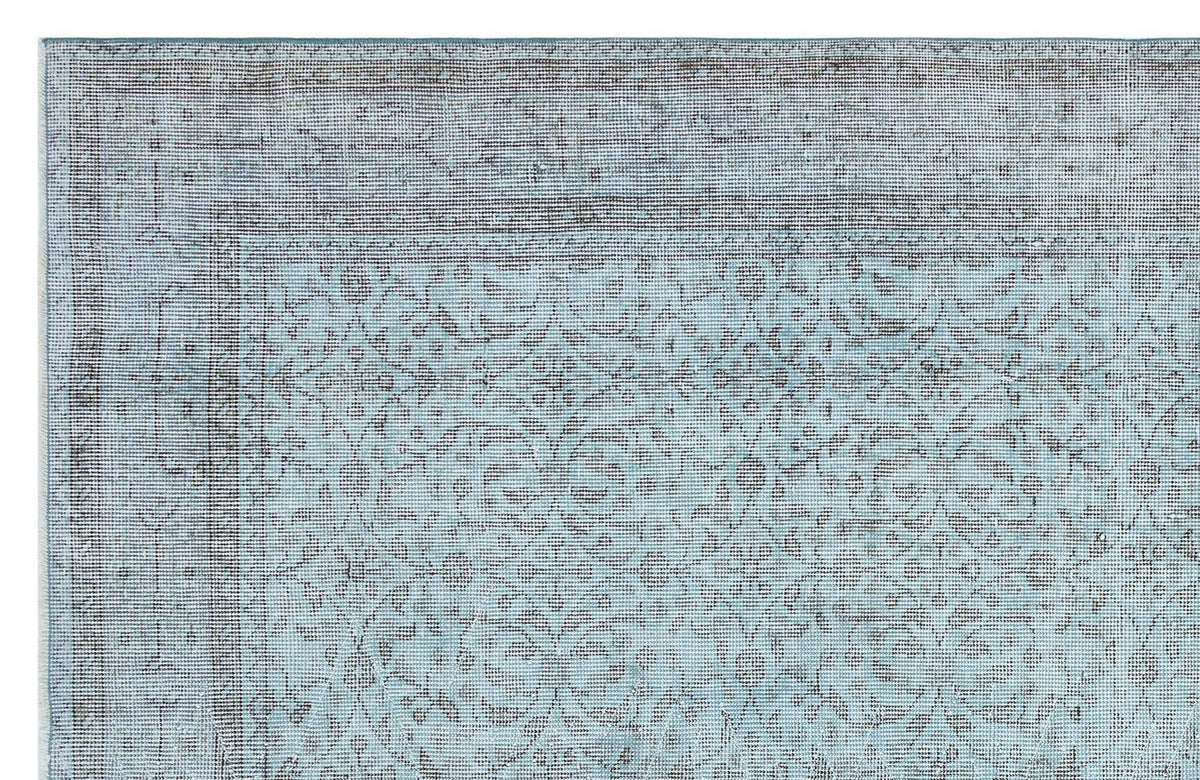 Light blue and charcoal grey rug with a traditional distressed floral medallion pattern and a wide border.