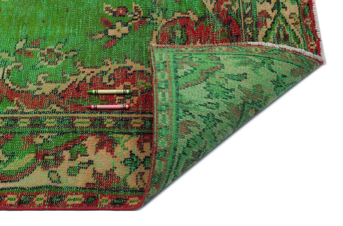 Load image 1 in gallery view. Green and red vintage-style rug with a traditional floral pattern, shown folded to reveal the underside.