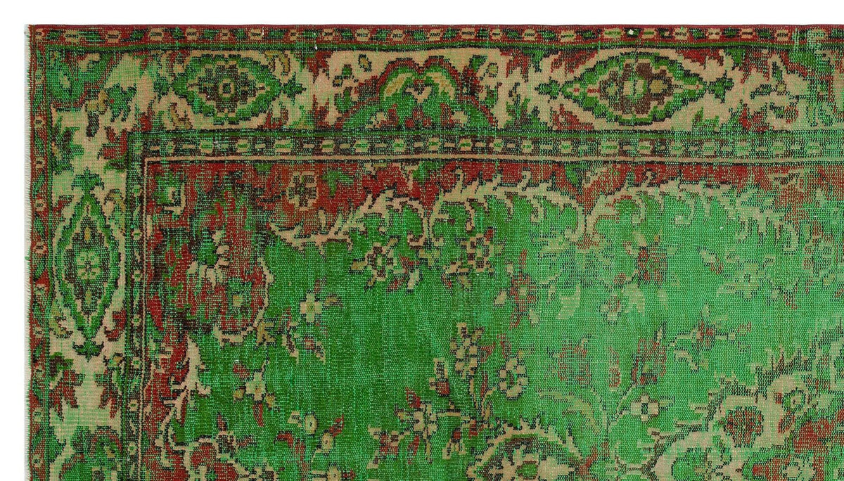 Distressed green and red vintage-style rug with a traditional floral medallion border and intricate botanical motifs.