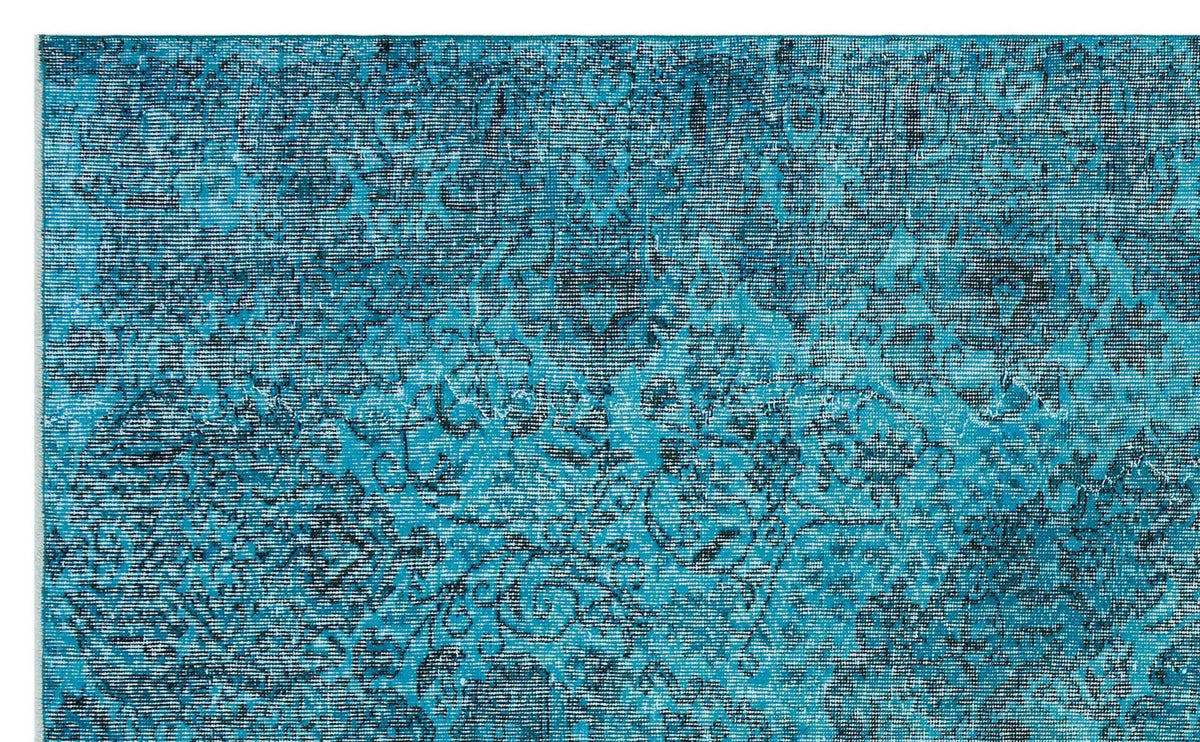 Teal and dark blue distressed rug with a faded traditional floral medallion pattern.