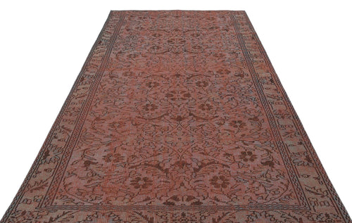 Load image 1 in gallery view. Terracotta and brown vintage-style rug with a repeating floral medallion pattern and a detailed border on a white background.