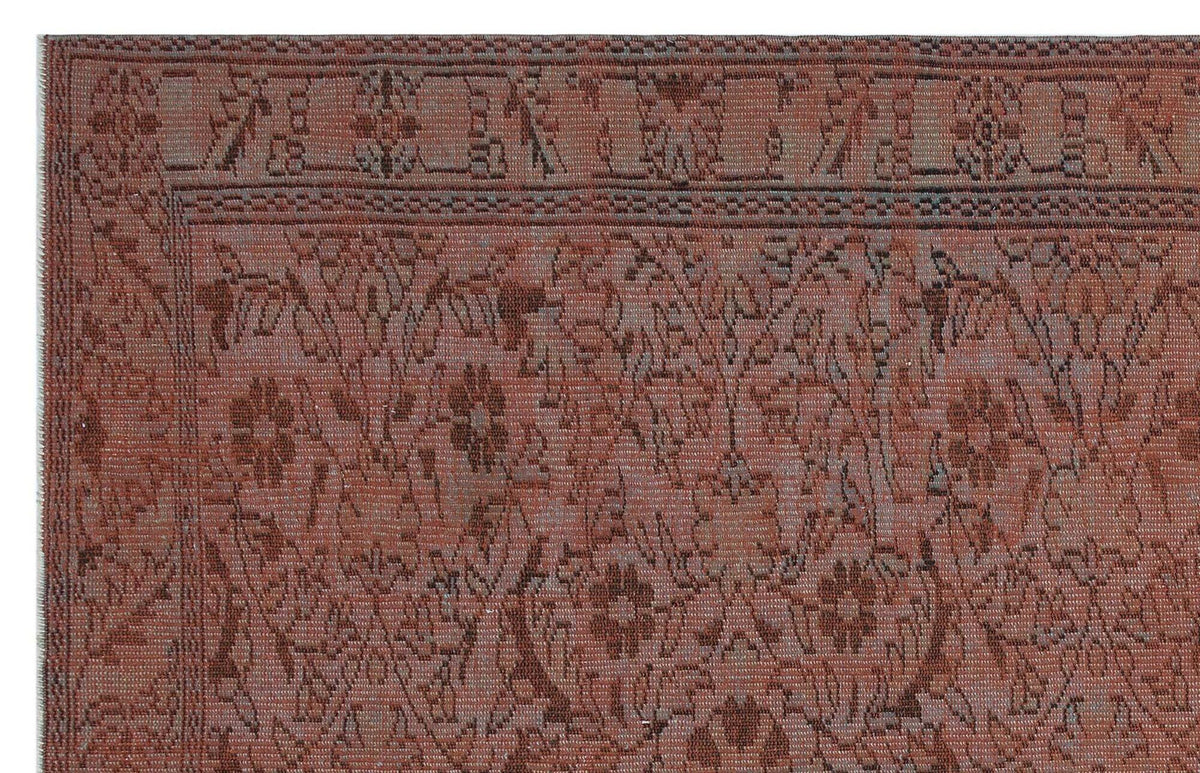 Terracotta and charcoal traditional rug with a distressed floral pattern and a geometric border.