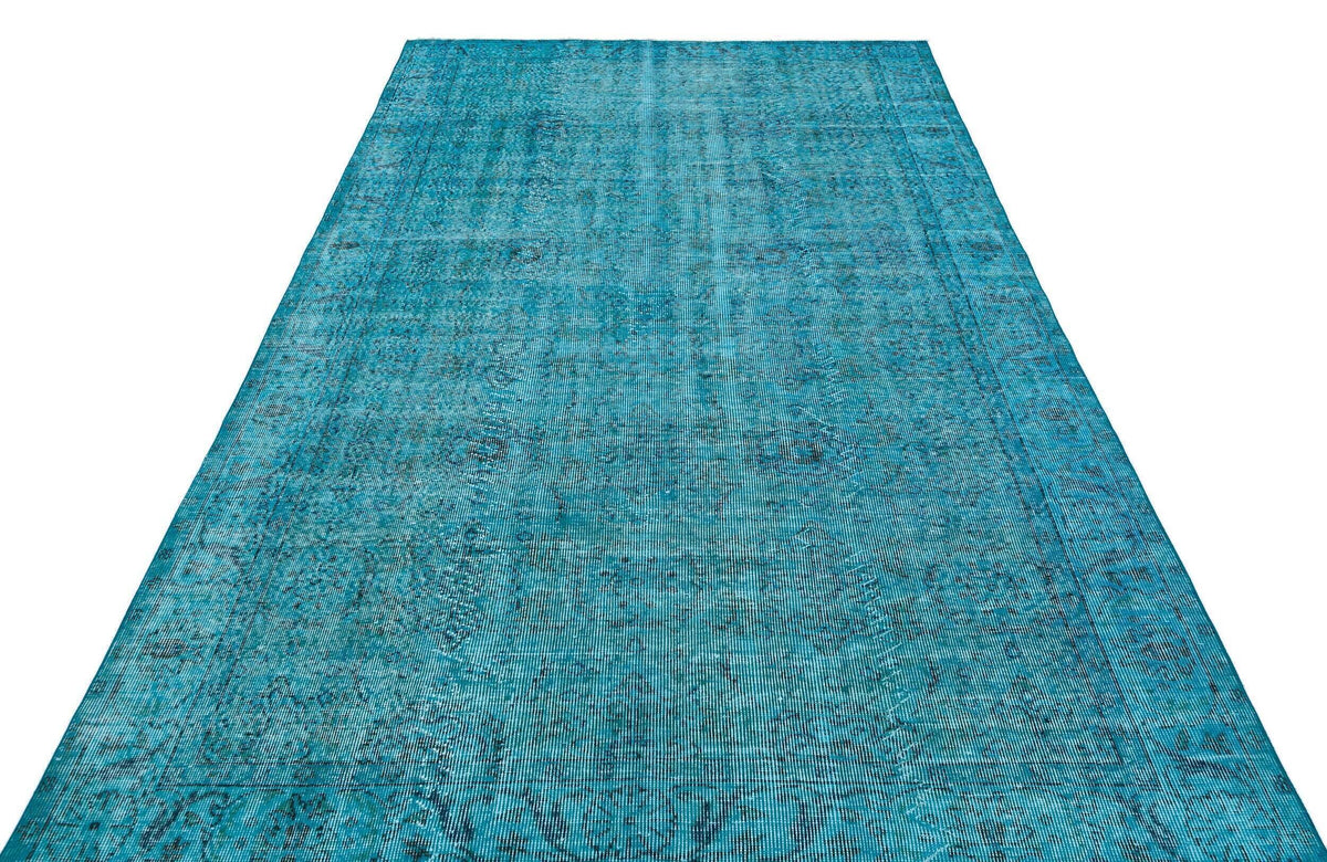 Teal vintage-style rug with a distressed, faded traditional medallion pattern on a white background.