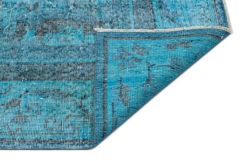 Load image 1 in gallery view. Bright blue distressed rug with a black traditional medallion pattern, shown with a corner folded over on white.