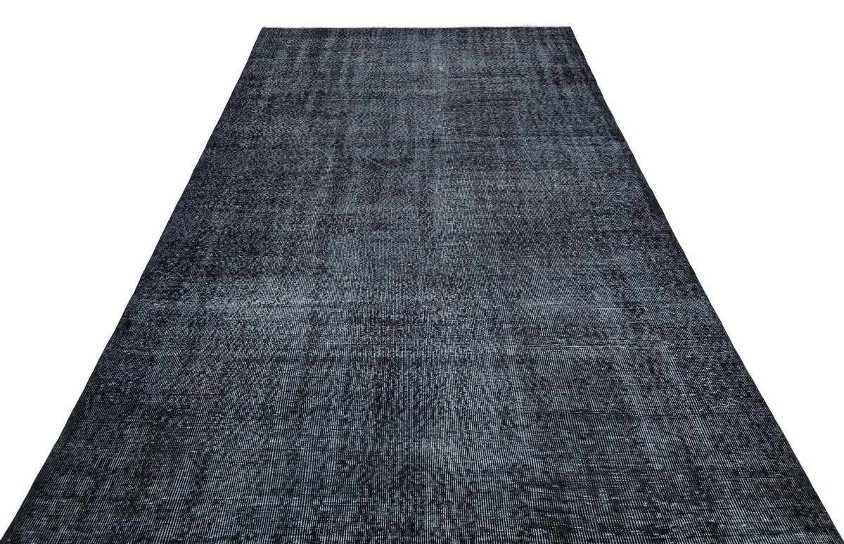 Charcoal and black distressed vintage-style rug with a subtle, faded texture on a white background.