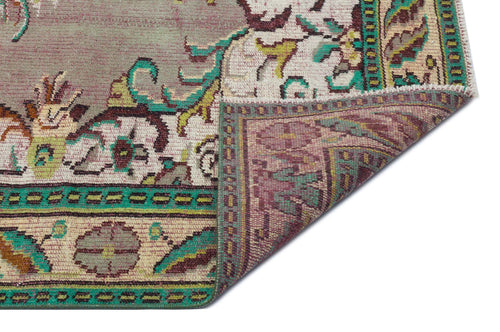 Load image 1 in gallery view. Distressed floral medallion rug in mauve, teal, and cream with a folded corner showing the reverse side.