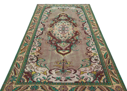 Load image 1 in gallery view. Vintage-style runner rug with a central medallion and floral border in muted mauve, teal, and brown on a white background.