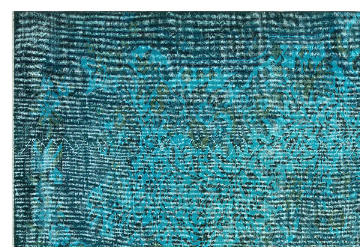 Teal and dark blue distressed rug with a faded traditional floral medallion pattern.