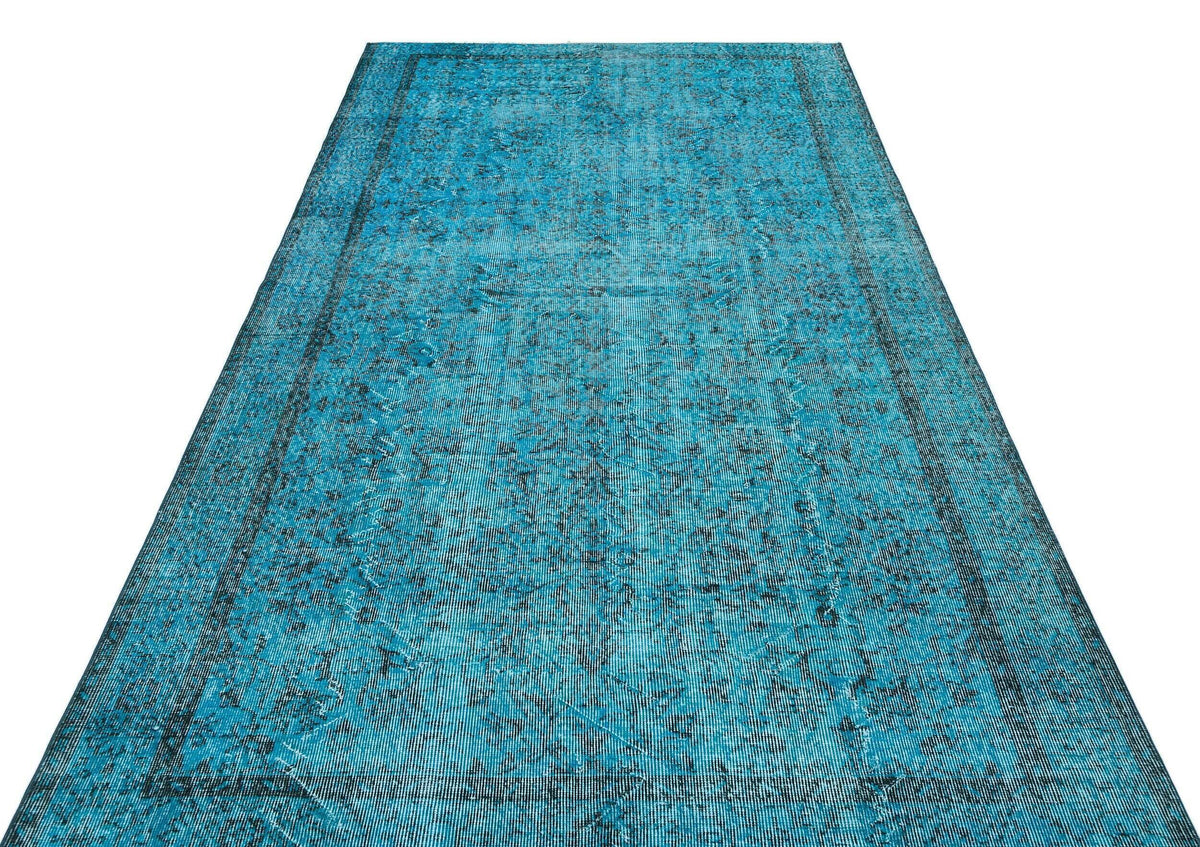 Turquoise and black distressed vintage-style rug with a faded traditional medallion pattern on a white background.
