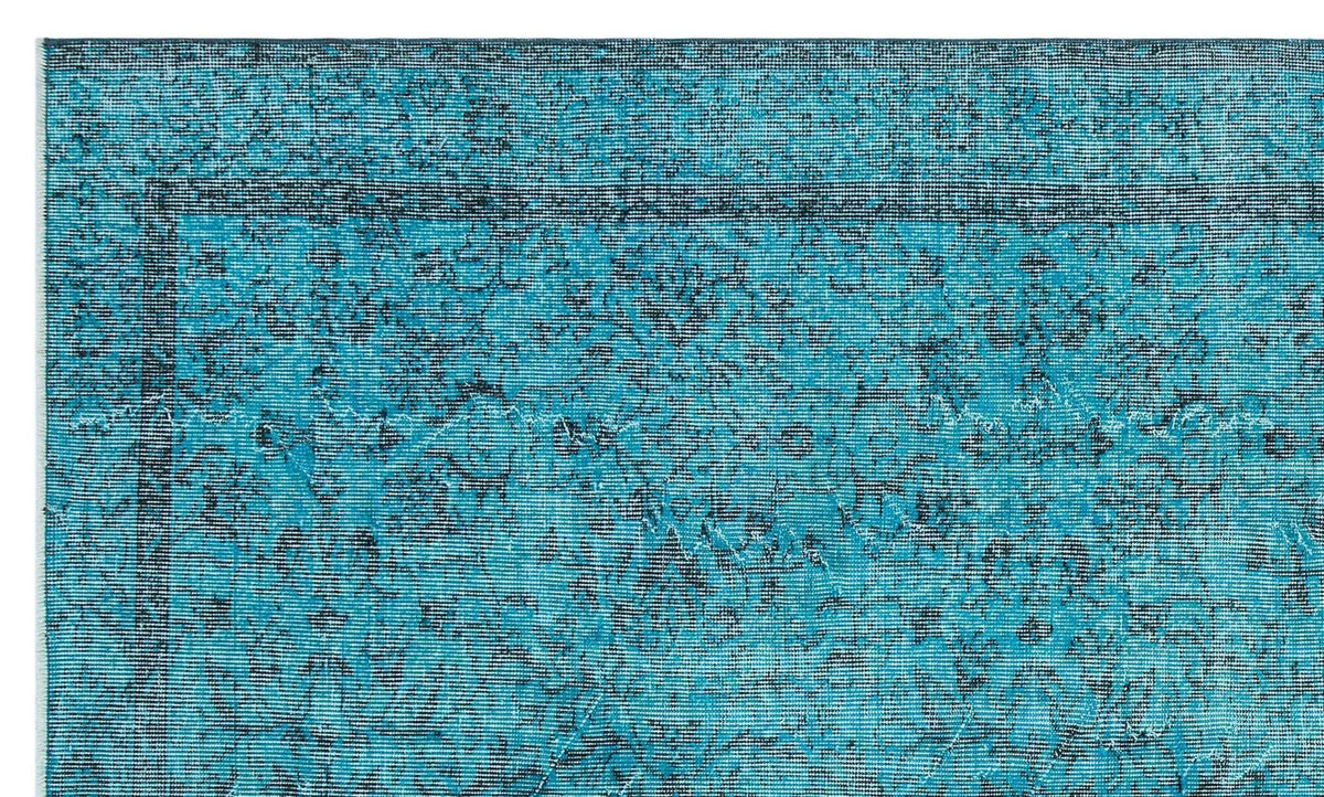 Teal and black distressed rug with a traditional floral medallion border and faded vintage pattern.