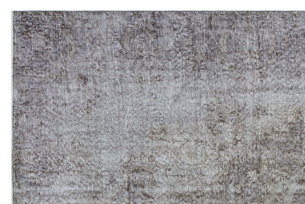 Grey and taupe distressed rug with a faded traditional medallion pattern.