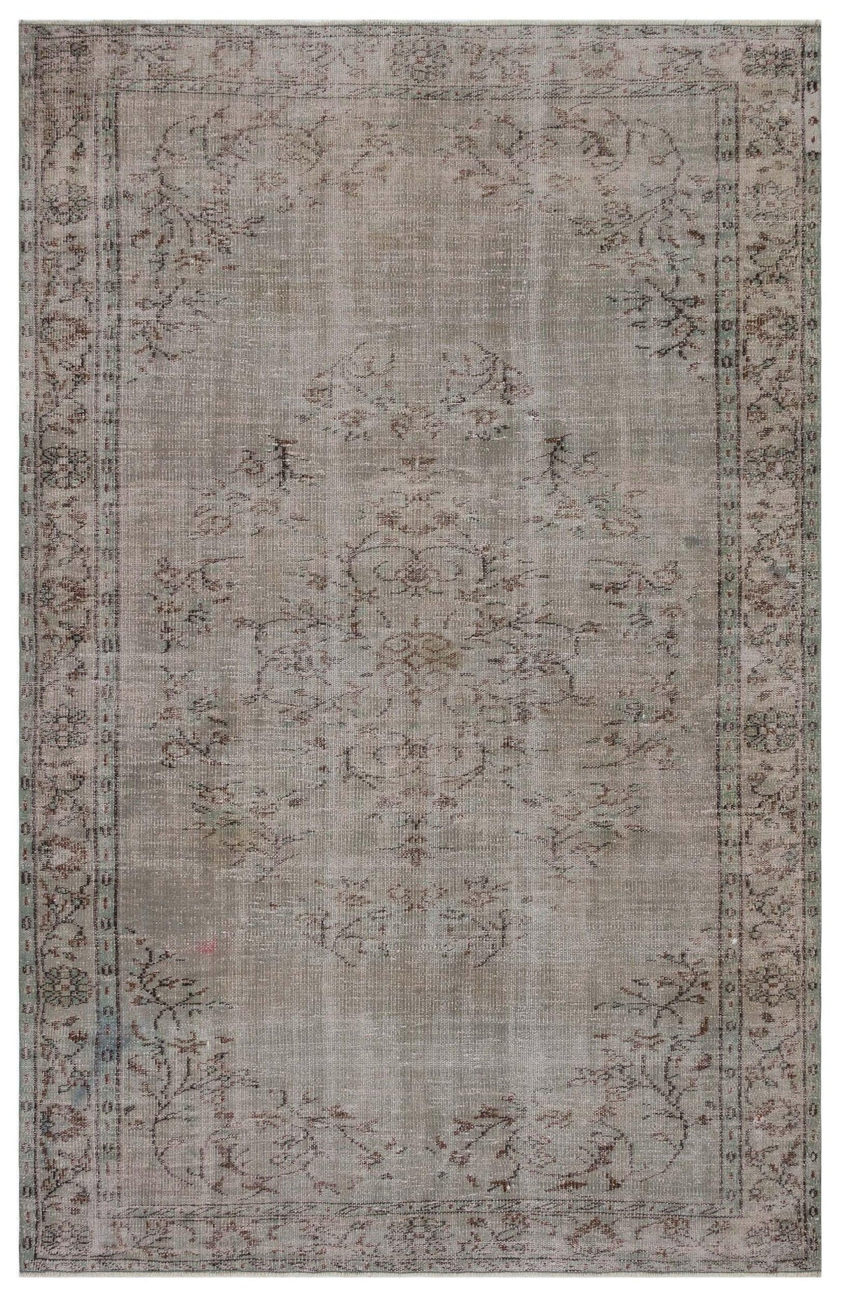 Distressed taupe and grey rug with a faded central floral medallion and intricate border pattern.