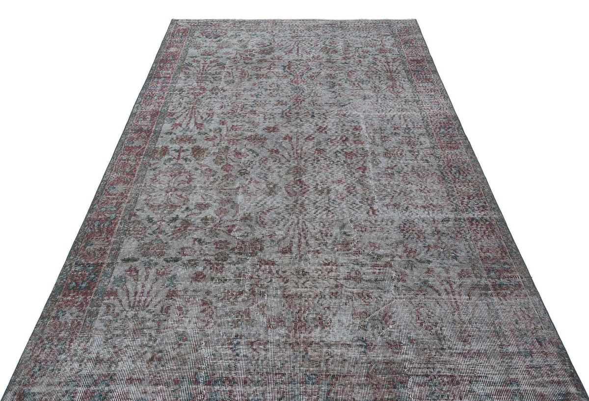 Grey, red, and blue distressed traditional rug with a faded floral medallion pattern on a white background.