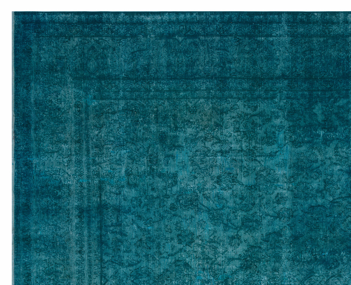 Teal rug with a distressed, faded traditional medallion pattern and a bordered edge.