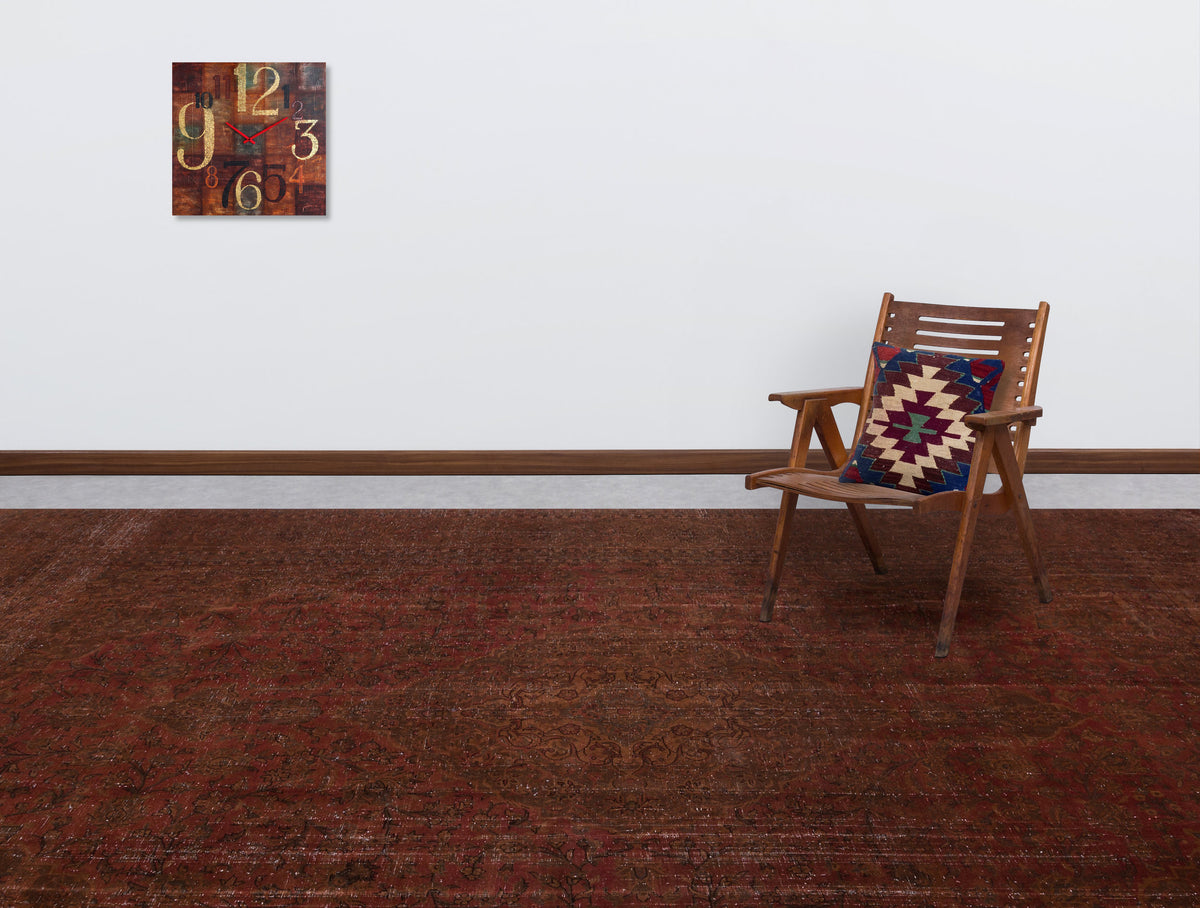 Deep red traditional rug with a distressed floral pattern, styled in a room with a wooden chair and wall clock.