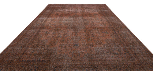 Load image 1 in gallery view. Distressed rust-colored rug with a faded traditional floral medallion pattern and dark blue border details.