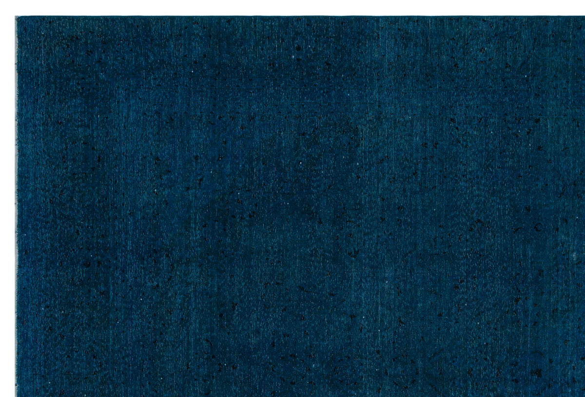 Deep teal rug with a distressed, monochromatic texture and subtle, faded traditional motifs.