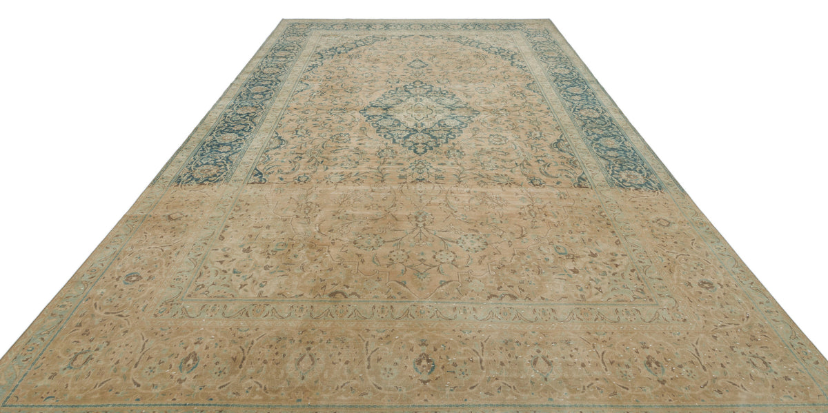 Tan and blue traditional rug with a central floral medallion and ornate border pattern on a white background.