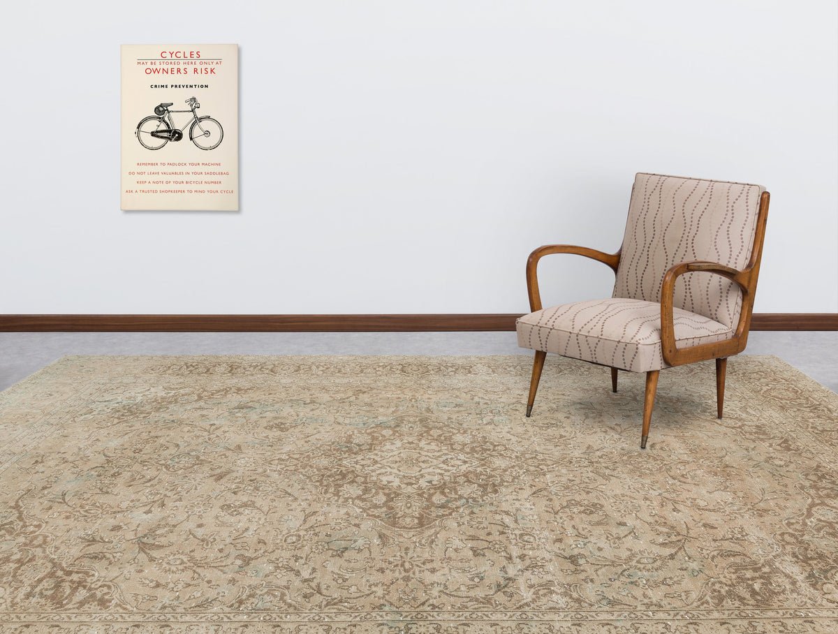 Beige and brown traditional medallion rug in a room with a patterned armchair and vintage bicycle wall art.