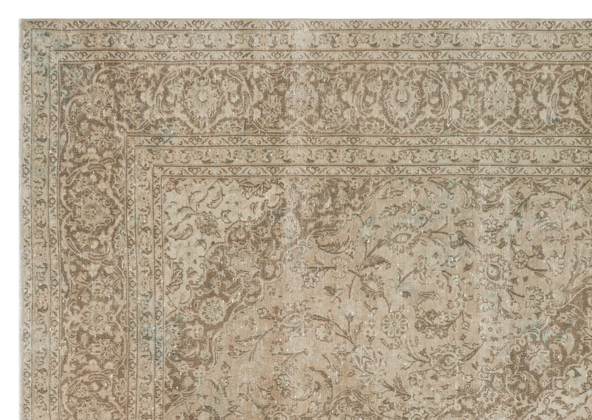Taupe and beige distressed rug with a traditional floral medallion pattern and ornate border.