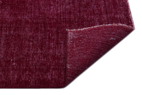 Load image 1 in gallery view. Deep burgundy rug with a distressed, textured finish and a folded corner showing the underside.