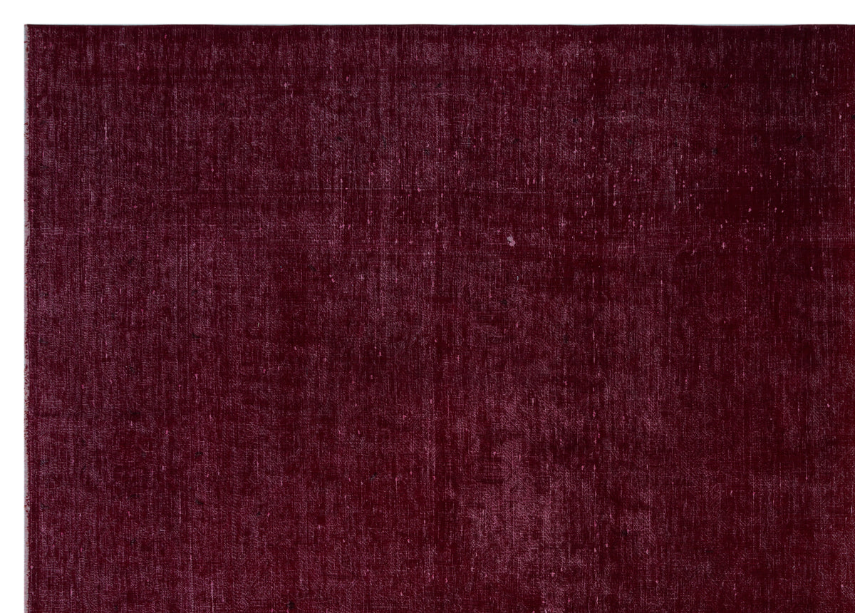 Deep burgundy solid-color rug with a distressed, textured finish.