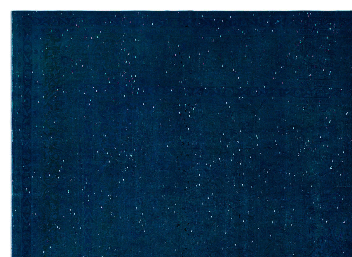 Deep navy blue rug with a distressed, speckled texture and a faint traditional border pattern.