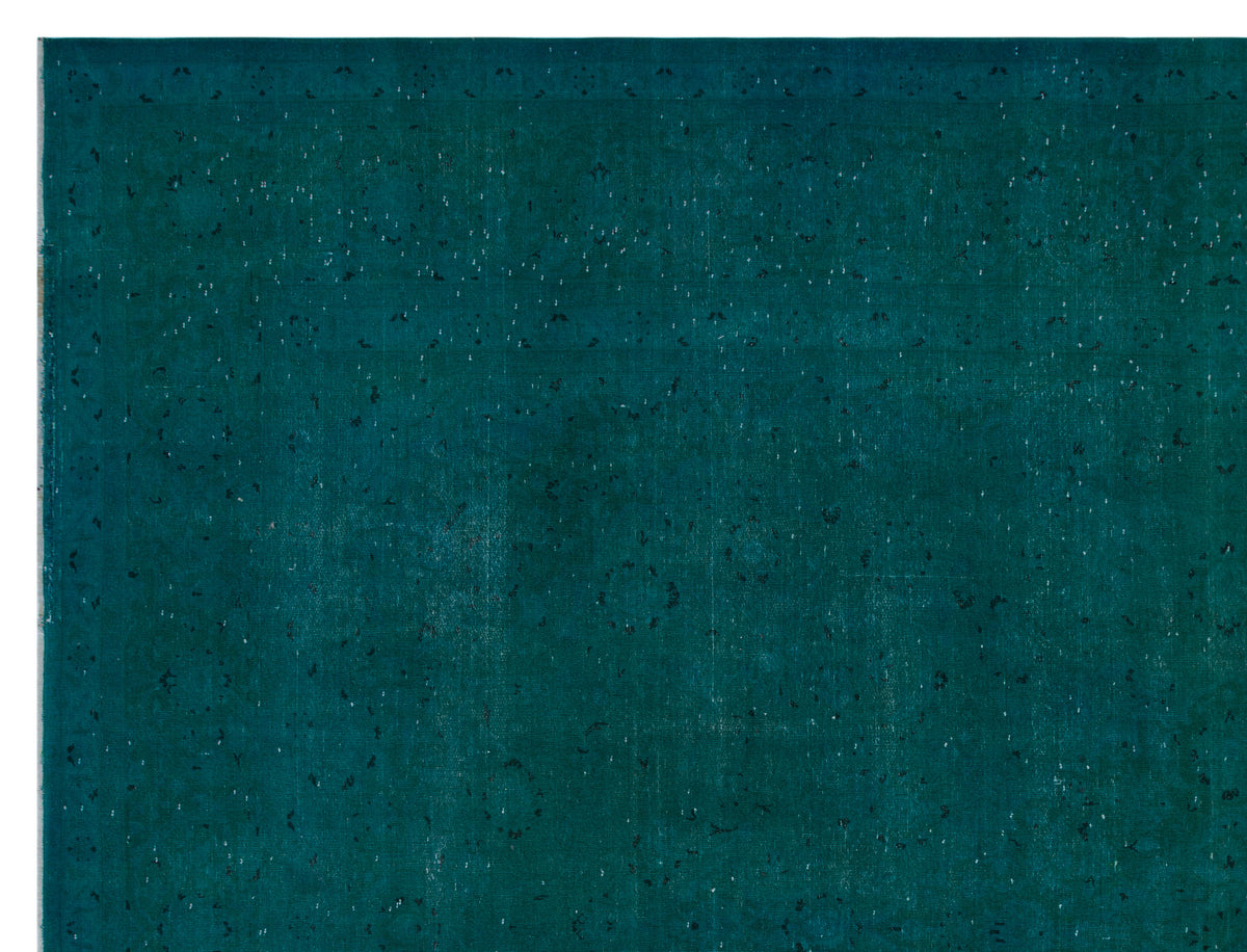 Deep teal vintage-style rug with a subtle, distressed floral medallion pattern and worn texture.