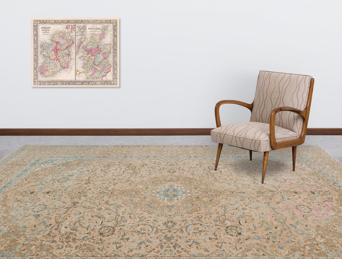Beige and blue traditional floral medallion rug in a room with a patterned armchair and a vintage map on the wall.