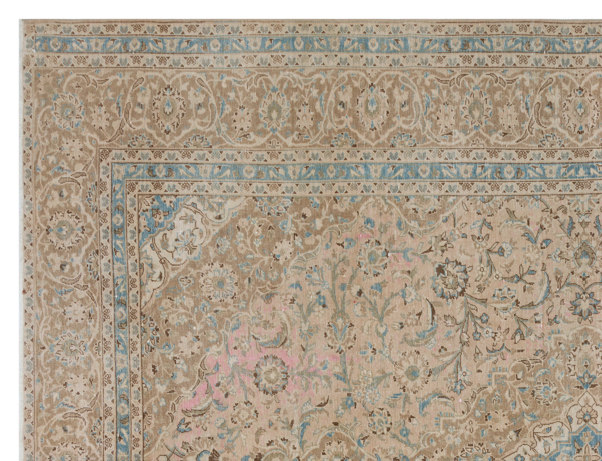 Tan traditional rug with blue and pink floral medallion patterns and a decorative border.