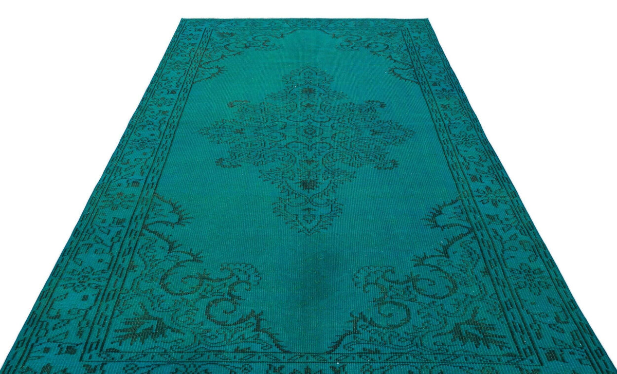 Teal rug with a black traditional medallion and border pattern on a white background.