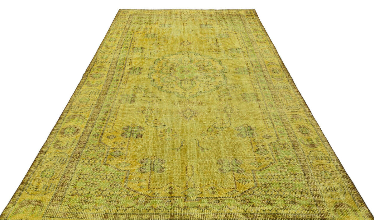 Yellow distressed vintage-style rug with a faded central medallion and ornate border pattern on a white background.
