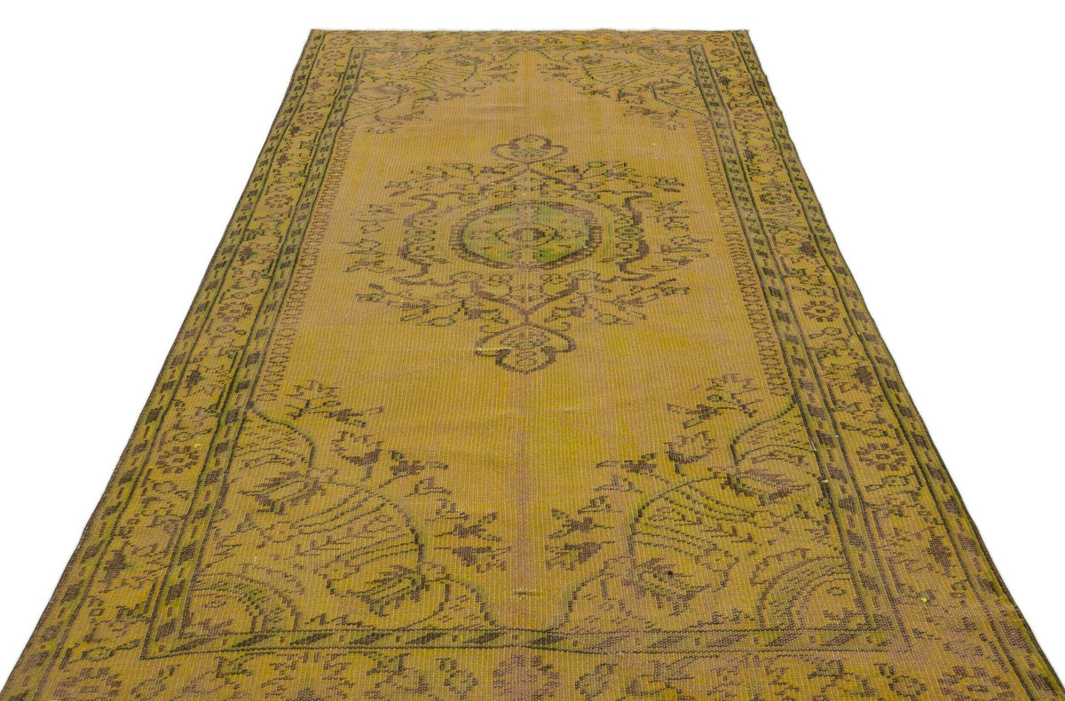 Mustard yellow vintage rug with a dark brown central medallion and ornate floral border on a white background.