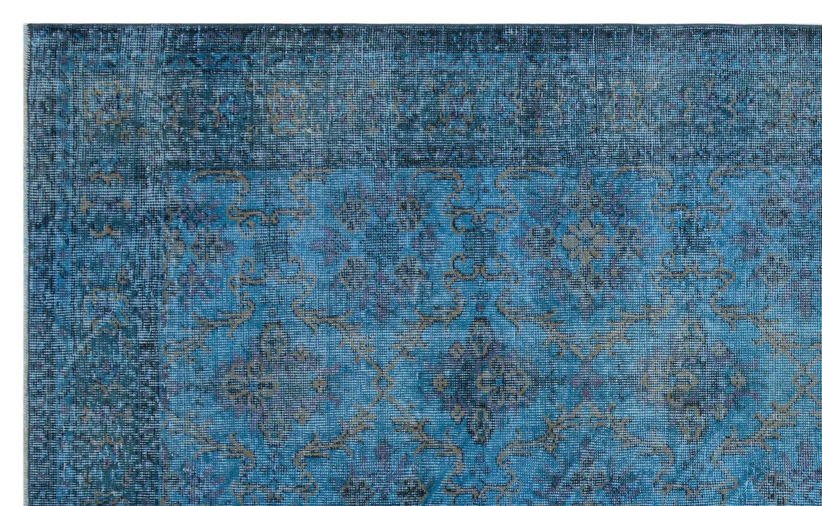 Distressed blue rug with a faded traditional floral medallion pattern and a dark border.