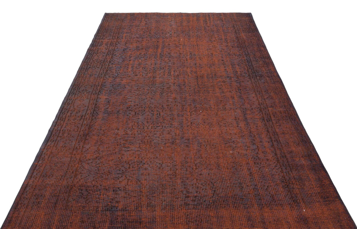 Distressed rust-red and charcoal vintage-style rug with a faint, faded traditional pattern on a white background.