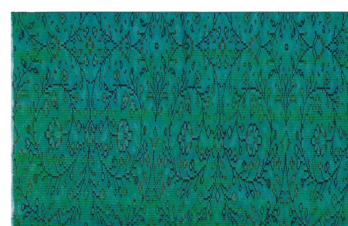 Teal rug with a distressed black floral and geometric medallion pattern.