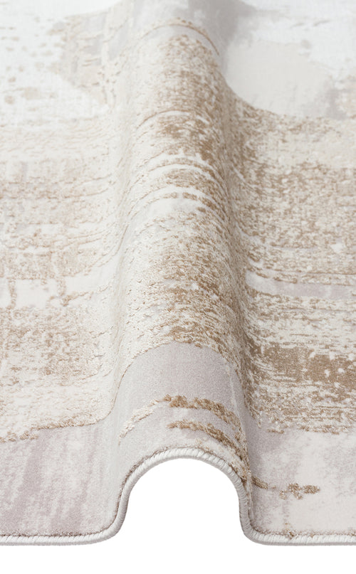 Bild 1 in Galerieansicht laden. Beige and cream area rug with a distressed, abstract textured pattern, shown folded on a white background.