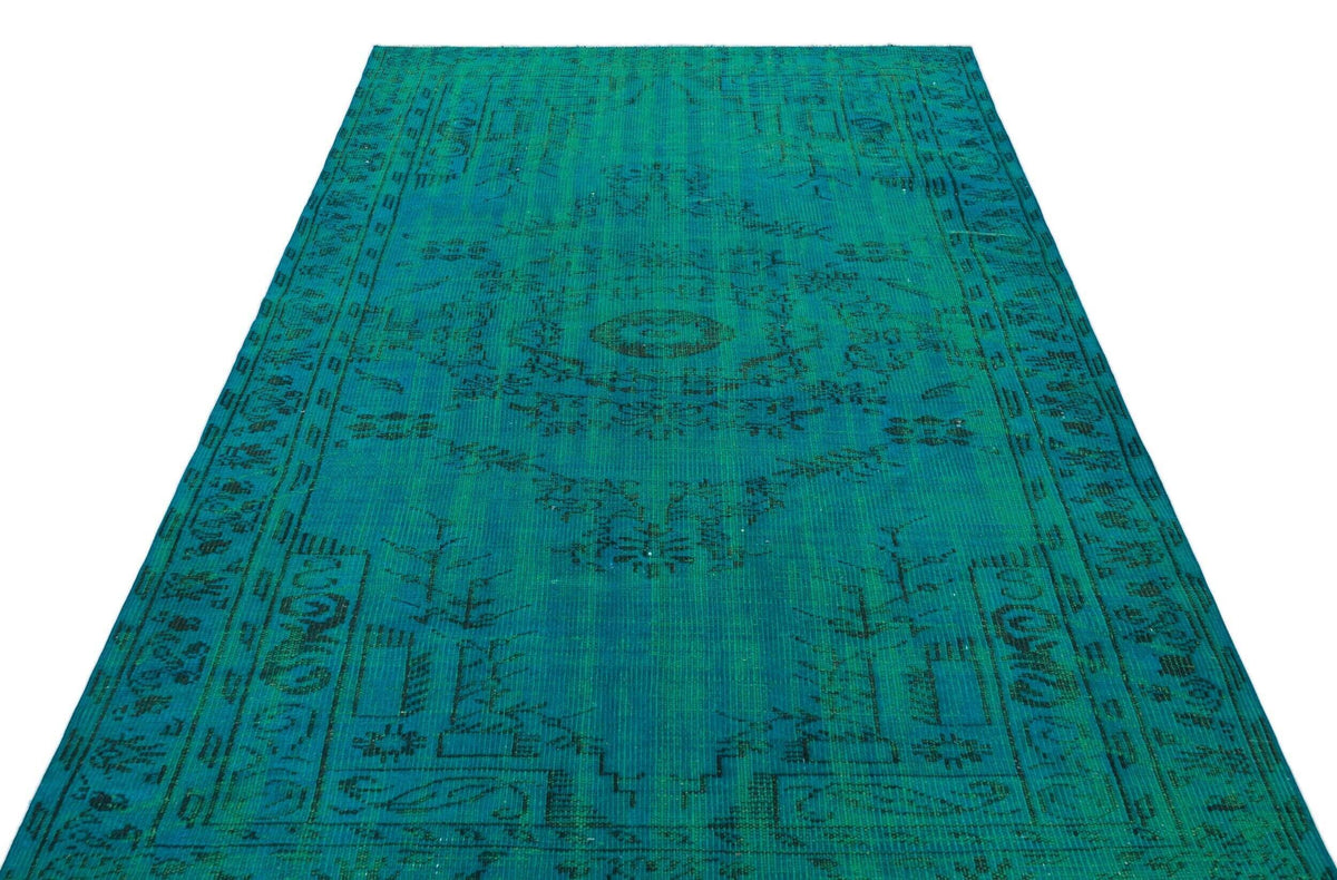 Teal and black distressed vintage-style rug with a central medallion and ornate border pattern on a white background.