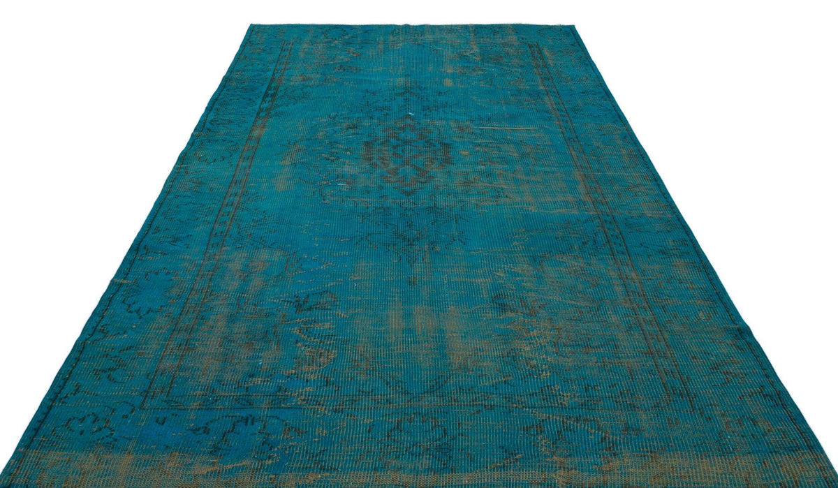 Teal and dark grey distressed rug with a traditional medallion pattern on a white background.