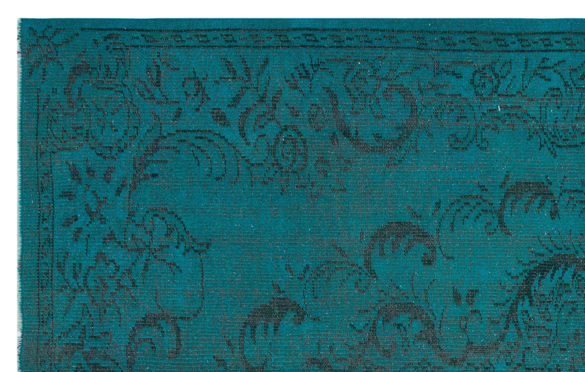Teal rug with a dark charcoal floral medallion pattern and a decorative border.