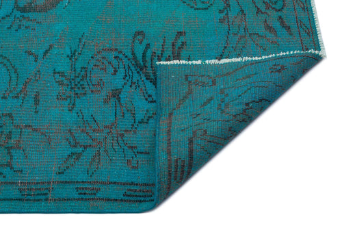 Load image 1 in gallery view. Teal rug with a dark grey floral pattern and a folded corner revealing the underside, isolated on a white background.