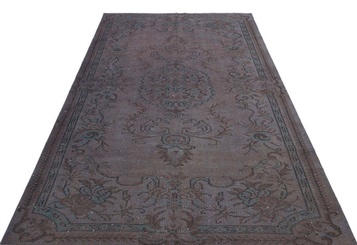 Load image 1 in gallery view. Dark brown and teal vintage-style rug with a central floral medallion and ornate border on a white background.