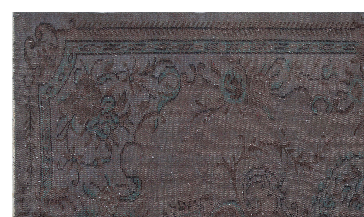 Dark charcoal and teal vintage-style rug with a distressed floral medallion border and intricate traditional motifs.
