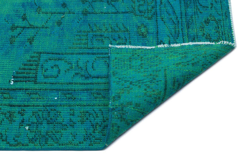 Load image 1 in gallery view. Teal and emerald green rug with a faded traditional medallion pattern, shown with a corner folded over.